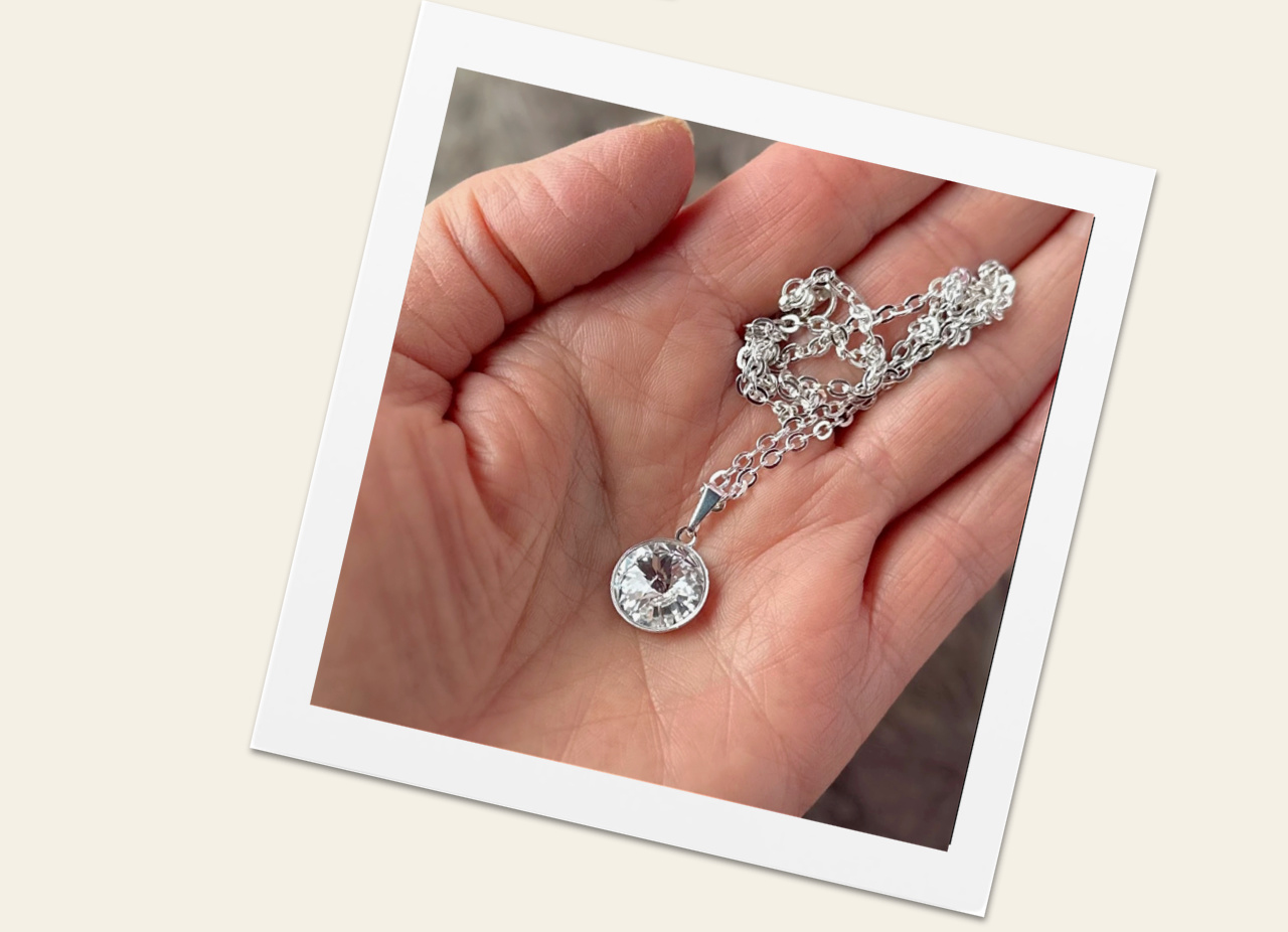 40 percent off Swarovski crystal rivoli necklace in open hand.