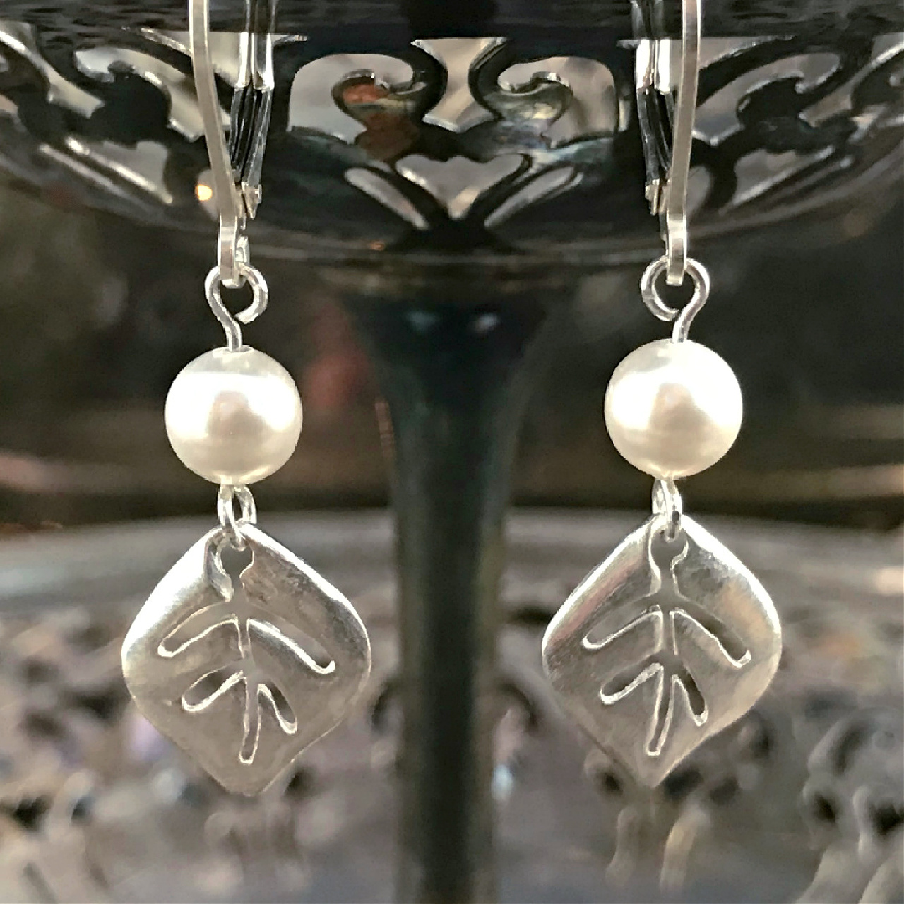 A pair of handcrafted, leaf-motif, sterling silver earrings, with white Swarovski crystal pearl on sale at Suzie Q Studio