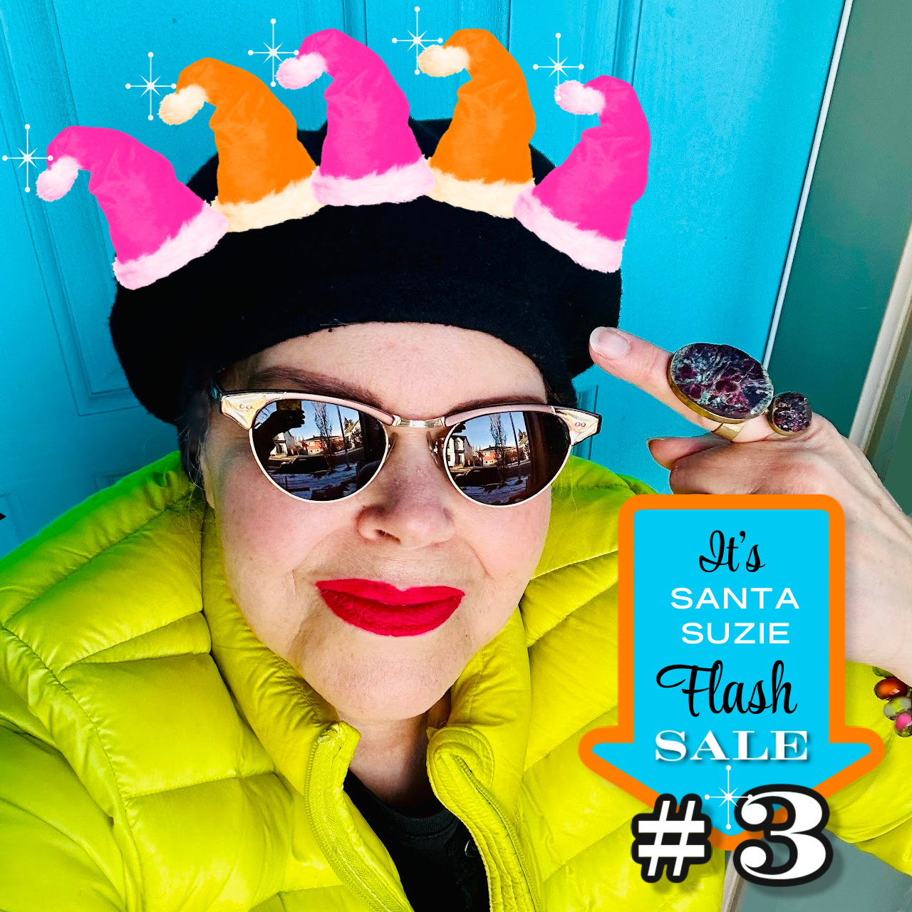 Woman wearing a black beret with mini, orange and pink Santa hats on top, promoting a sale at Suzie Q Studio.
