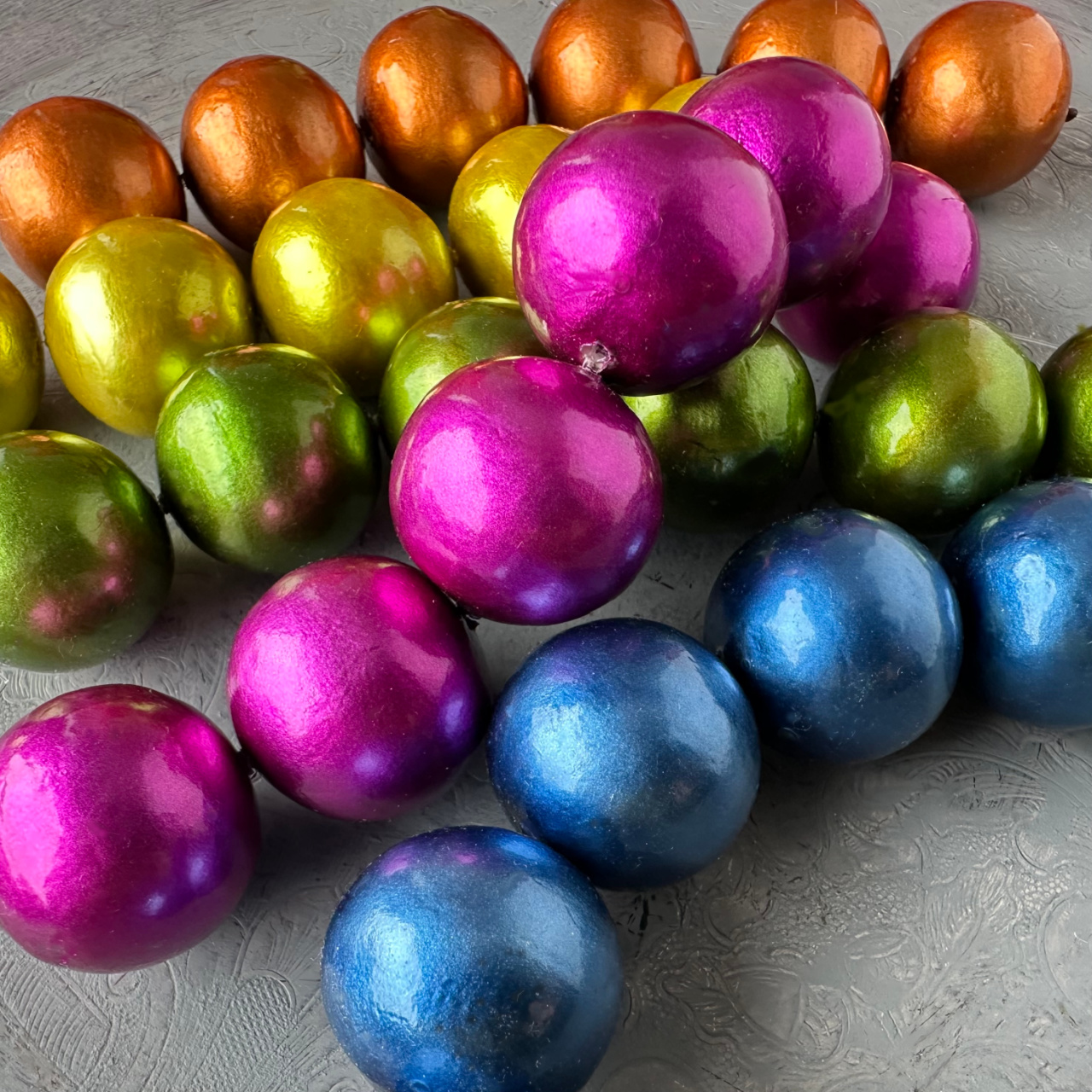 Strands of  new, bright coloured round, cotton pearl beads, available at Suzie Q Studio.