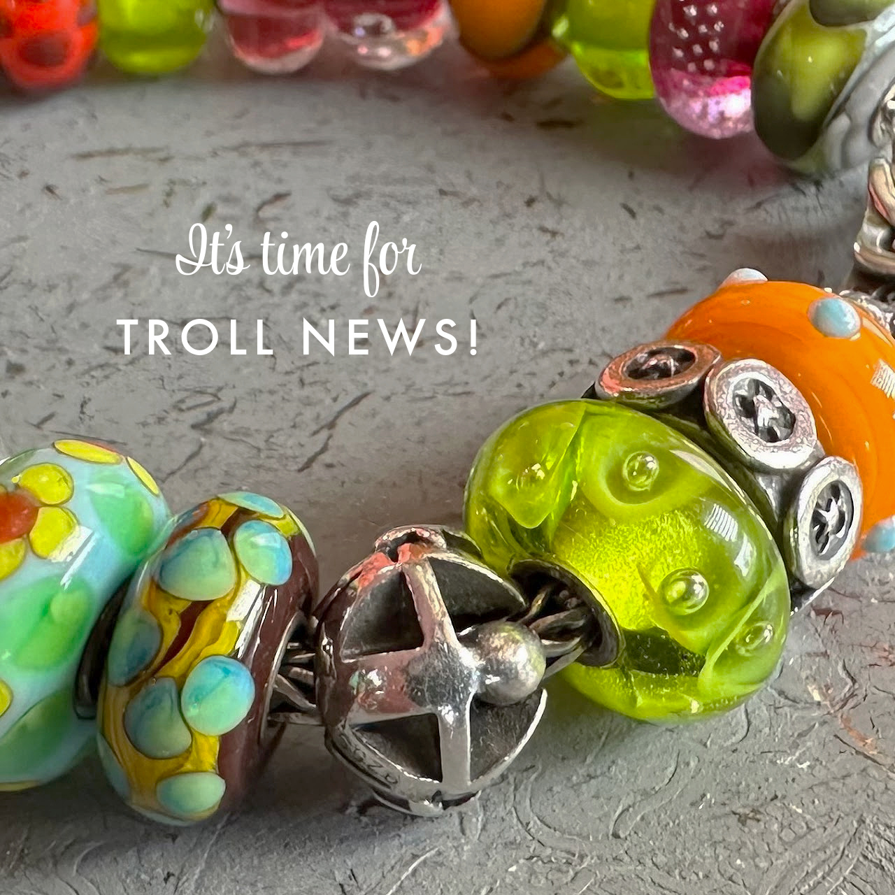 Colourful glass and sterling silver Trollbeads bracelet  on a grey background, with the wording, "It's time for Troll News"
